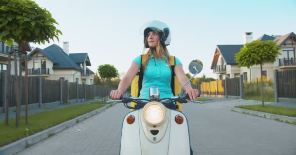 Ritratto di donna caucasica premurosa che cerca l'indirizzo del cliente. Bella giovane operaio di consegna in sella a uno scooter in fondo alla strada. E-commerce, shopping sicuro. — Video Stock