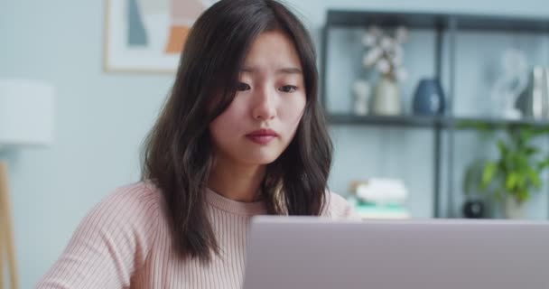 Przystojna Azjatka siedząca przy stole i budząca się w biurze. Inteligentna młoda kobieta-freelancer otwierająca laptopa i otrzymująca powiadomienie, wpisująca e-mail. Biznes, praca, koncepcja Internetu. — Wideo stockowe