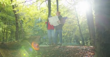 Kız arkadaşına aşık olan genç yürüyüşçülerin orta planı, birlikte haritayı kontrol edip, yürüyüşe çıkarlar. Sırt çantası, orman gezisi, macera, yürüyüş. Aşk hikayesi. Doğada seyahat eden insanlar kavramı.
