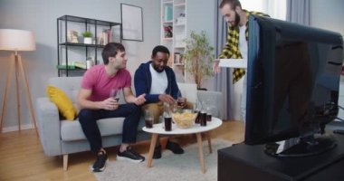 Karışık ırk arkadaşları TV 'de futbol maçı kanalını izlemek için bir araya geldiler. Genç adam yiyecek pizzası getiriyor ve en iyi arkadaşlarıyla eğleniyor. Atıştırmalıklar ve içecekler. Hayran konsepti