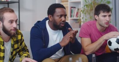 Afrika kökenli Amerikalı ve Kafkas erkek arkadaşlarının yakın çekimleri. Evde oturmuş, endişeleniyor ve içiyorlar. Maçta favori takım için tezahürat yapıyorlar.