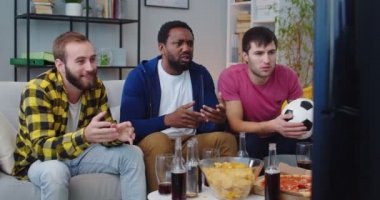 Televizyonda futbol maçı için tezahürat yapan üç yakışıklı beyaz ve Afro-Amerikan erkeği kanepede oturmuş oyundan hayal kırıklığına uğruyor. Televizyonda spor kanalını izleyen erkek arkadaşlar bir araya geldi
