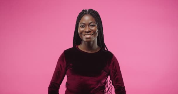 Close up retrato de alegre jovem mulher afro-americana bonita sorrindo de bom humor e de pé sob chuva dólar isolado no fundo da parede rosa. muitos dinheiro caindo em fêmea. Conceito de sucesso — Vídeo de Stock