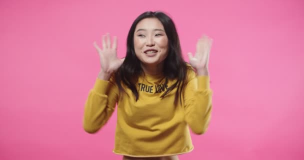 Portrait of cheerful young beautiful Asian woman teen emotionally reacting to news jumping and feeling excited winning lottery, happy emotions, surprised winner, making gestures with hands — Stock video