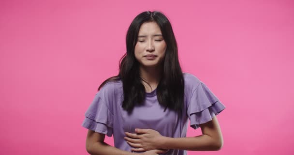 Πορτρέτο της Ασίας άρρωστος αδιαθεσία ασιατική όμορφη γυναίκα στέκεται απομονωμένη σε ροζ φόντο έχοντας πρόβλημα υγείας αισθάνεται φρικτό πόνο στο στομάχι, που πάσχουν από οδυνηρό συναίσθημα. Έννοια υγειονομικής περίθαλψης — Αρχείο Βίντεο