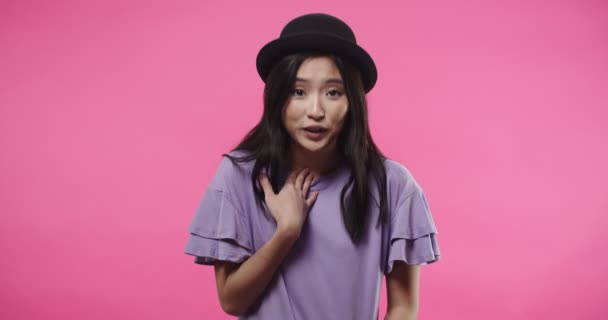 Közelkép portré vidám boldog gyönyörű ázsiai nő fekete kalapban áll elszigetelt rózsa rózsaszín háttér és megkérdezte tőlem, tagadása és elutasítása valamit, zavaros érzés — Stock videók