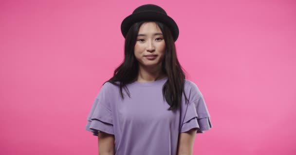 身穿紫色上衣、头戴黑色帽子、快乐快乐的年轻亚洲美女的画像，看着镜头，脸上带着惊讶的表情，不相信她的好运。积极情绪概念 — 图库视频影像