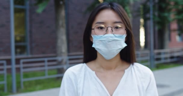 流行病，一个年轻的旅游妇女的肖像，戴着保护面具在街上的人群。covid concept health and safety, N1H1 coronavirus quarantine, second wave covid virus protection — 图库视频影像