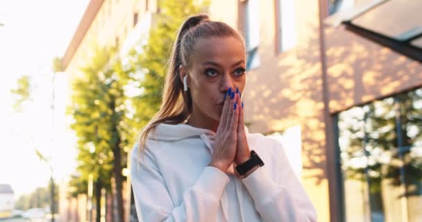 Beautiful female athlete in sportswear preparing for jogging marathon in street. Young Caucasian woman joining hands, breathing deeply and running in morning. Healthy, active lifestyle concept. — Stock Video