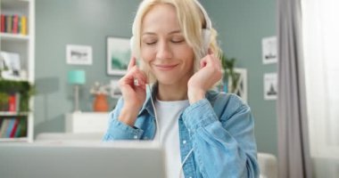 Mutlu, genç, beyaz bir kadının portresini yakından çek. Kulaklık tak ve müzik dinle. Dans ederken dans et.