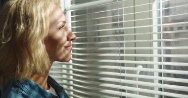 Kafkasyalı mutlu genç bir bayanın karanlık bir odada dikilip hayallere dalmış gülümseyişine yakından bakın. Oldukça neşeli bir kadın kameraya iyi haliyle bakıyor, yandan bakıyor.