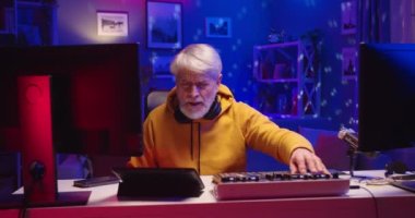 Neşeli Kafkasyalı kıdemli DJ 'in portresi, stüdyo atölyesinde müzik çalmaktan keyif alıyor. Plak plaka üzerinde profesyonel mikser konsolu ekipmanı kullanarak neon ışıkta beat ses yaratıyor.