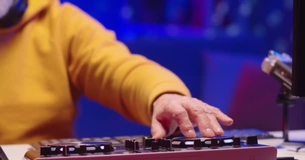 Close up shot of Caucasian old man DJ hands playing music at home recording studio workshop creating beat sound using professional mixer console. Making music on vinyl plate, musician concept — Stock Video