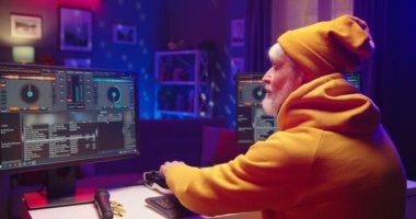 Kafkasyalı mutlu yaşlı DJ 'in arka koltuğu, plaka üzerinde ses yaratıyor. Akşamları müzik stüdyosunda oturup bilgisayar monitörüne bakarak mikser konsolunda şarkı karıştırıyor. Kapat.