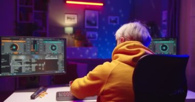 Kafkas stili yaşlı erkek ses mühendisi modern şarkı yaratmak için karıştırma tahtası ve yazılım kullanıyor. Yaratıcı kıdemli müzisyen yeni yeni bir şarkı üretmek için masa kontrol yüzeyinde çalışıyor.