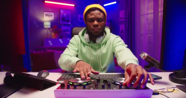 Stílusos hűvös afro-amerikai boldog érzelmi profi DJ játszik klub zene lemezjátszó konzol ül otthon felvétel stúdió kaparás vinyl plate Fiatal zenész létre hangok — Stock videók