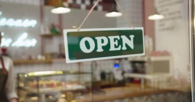 Çalışkan bayan kafe sahibi Coronavirus ve kriz nedeniyle kafeyi kapatıyor. Tıbbi maske takan yetişkin bir beyaz kadın. Açık 'tan Kapalı' ya geçiş tabelası. Covid-19, karantina konsepti..