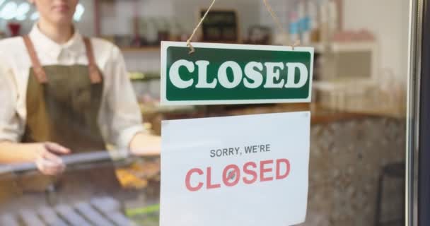 Außenansicht einer erwachsenen Kaffeehausbesitzerin, die sich dem Fenster nähert und Papier abreißt. Kaukasische Barkeeperin klebt Sorry, Ware Closed Ankündigung wegen Lockdown. Krisenkonzept für Unternehmen. — Stockvideo