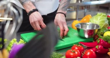 Yakından, yeşil rezene doğrayan, sebzeli salata hazırlayan bir adam resmi. Maydanoz kesen erkek şef. Yemek hazırlama. Aşçılık, aşçılık, restoran mutfak konsepti.