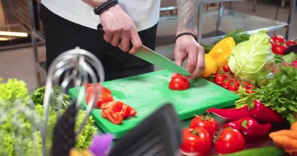 Close up de homem tatuado mãos cortando tomate trabalhando no restaurante. Trabalho de chef na cozinha do restaurante, corte de legumes, preparação de salada de produtos alimentares de corte. Culinária, culinária, cozinhar profissão — Vídeo de Stock