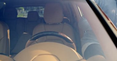 Yakışıklı genç adamın araba kapısını açmasına, direksiyona geçmesine, emniyet kemerini takmasına ve yeni lüks arabaya dokunmasına, yeni satın almanın mutlu bir şekilde gülümsemesine. Yaşam tarzı, yol, araba, sürücü kavramı.