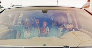 Ailelerin ve heyecanlı çocuklarının önünde oyuncaklarıyla gülümseyen araba sürücüleri. Genç bir aile yazın arabada birlikte eğleniyor. Yaşam tarzı kavramı, mutlu aile, birlikte seyahat..