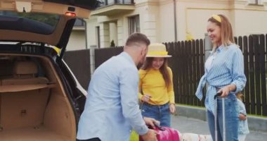 Aile birlikte seyahate çıkıyor. Babam bagajda bavul topluyor, karısına beş bin veriyor ve arabaya biniyor. Mutlu aile birlikte eğleniyor. Yaşam tarzı kavramı, mutlu aile, birlikte seyahat..