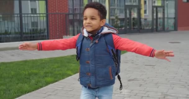 Närbild av afroamerikanska söta glada skolpojke kör med öppnade armar från skolan efter klasser utomhus på gatan till pappa. Glad pojke unge på gott humör träffa kärleksfull far efter lektionerna. — Stockvideo