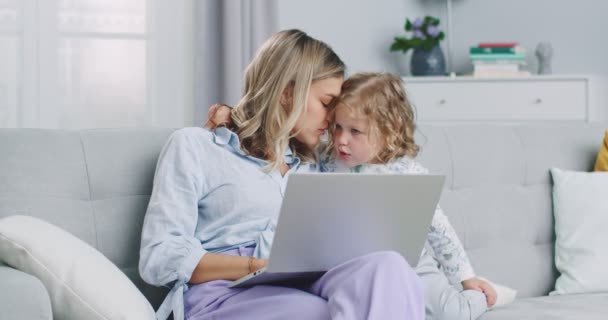 Mittelplan der Mutter Multitasking mit Laptop-Computer zu Hause mit ihrem Baby. Candide echte und echte Leben Mama arbeitet und Elternschaft. Selbstisolierung. Konzept von Familie, Elternschaft, Zweisamkeit. — Stockvideo