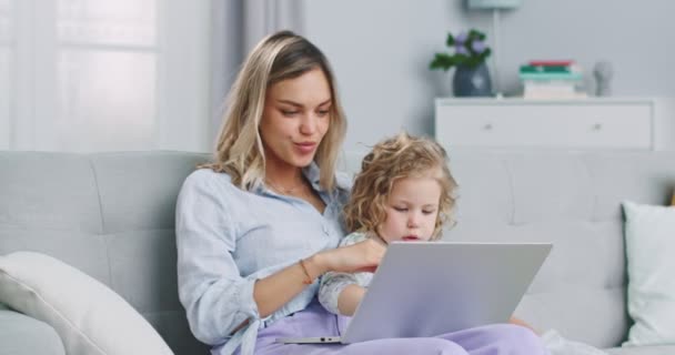 Middle plan of happy parent mother and cute small child κόρη looking at laptop screen webcam having fun making conference video call chat at at home relaxing. — Αρχείο Βίντεο