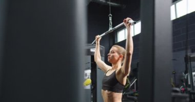 Genç ve güçlü kadın antrenörün gizli kamera görüntüsü spor salonunda trx fitness makinesiyle şınav çekerken görülüyor. Spor sporu ve sağlıklı yaşam tarzı konsepti