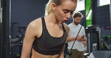 Çatı katındaki spor salonunda traks fitness kayışlarıyla kollarını çalıştırırken şınav çeken güçlü ve sağlıklı kadınların portre görüntüsü. Egzersiz ve sağlıklı yaşam tarzı kavramı