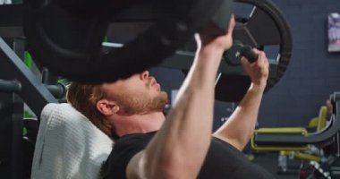 Güçlü adamın kollarını spor salonunda eğitirken özel makinede güç eğitimi aldığını gördüm. Spor ve spor konsepti