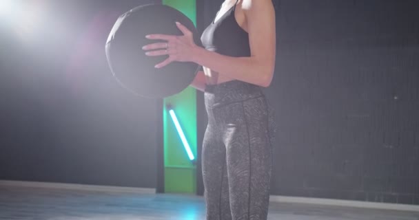 Спортивная молодая блондинка в спортивной одежде делает основные упражнения с мячом для упражнений во время тренировки в одиночку в оздоровительном клубе. Концепция спорта и отдыха — стоковое видео