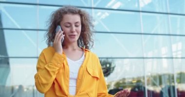 Beyaz, neşeli, güzel bir bayan cep telefonundan arıyor. Yüzünde gülümseme var ve dışarıda tek başına yürüyor. Kasabada akıllı telefondan konuşan neşeli bir kadın. Portre, şehir konsepti