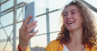 Kasabanın dışında dikilen ve akıllı telefondan görüntülü sohbet eden güzel, beyaz, mutlu bir kadının portresini yakından çek. Cep telefonuyla görüntülü konuşma yapan güzel bir kadın. Kentsel tarz kavramı