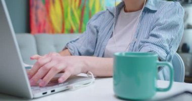 Kafkasyalı genç ve güzel bir kadının masada otururken kulaklıkla müzik dinlemesini ve Cabiet 'in odasındaki laptopta yazmasını kapat. Öğrenci öğrenimi, mesafe çalışması, teknoloji konsepti