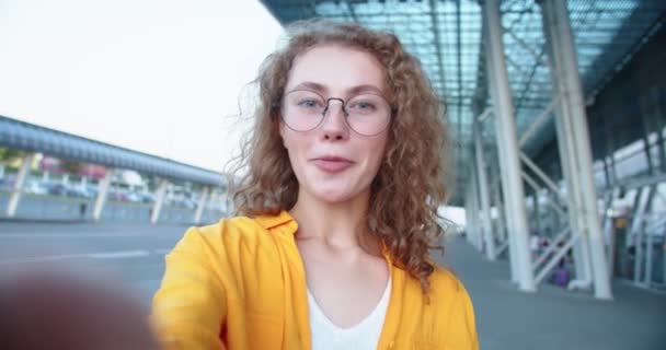 POV of happy beautiful Caucasian woman in glasses videochatting on street with smile on face while standing outdoors. Close up of joyful female speaking on video call on internet. Chat concept — Stock Video