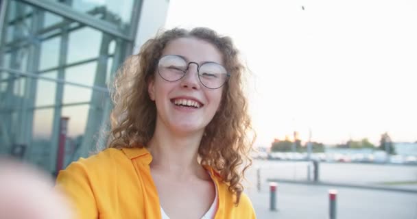 Close up portrait of happy pretty Caucasian woman in glasses laughing having online video conference on street outdoor. POV of cheerful female talk on video chat on internet. Conversation concept — Stock Video