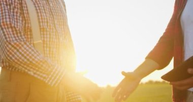 Genç çiftçi ile tarladaki kanepesi arasındaki tokalaşma görüntüsünü kırptım. Hasat sırasında arka planda günbatımı vardı.