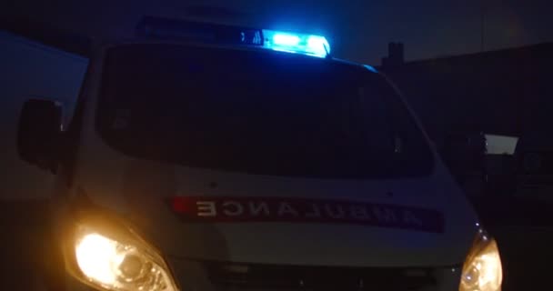 Auto di ambulanza con luci blu in strada in buio evning. Veicolo paramedico con fari in città all'aperto durante il turno di notte. Automobile di medici al buio. — Video Stock