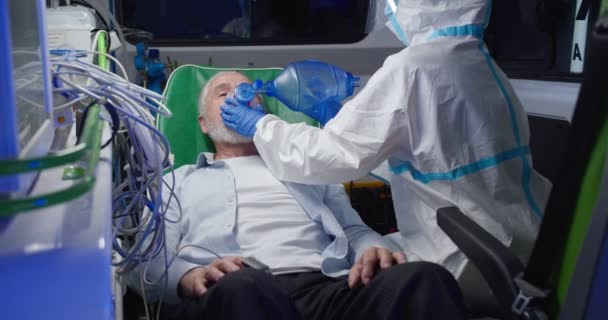 Notarzt rettet alten Mann im Krankenwagen vor Coronavirus Sanitäter geben dem Patienten Sauerstoff. Reanimation. Medizinische Arbeit während der Covid-19-Pandemie. Erste Hilfe und Reanimation. — Stockvideo