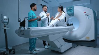 Nörolog doktor ve üniformalı hemşire hastanın yanında durup prosedürü açıklar. Hasta, tıbbi personelin anlatımını dikkatle dinliyor. Tıp, sağlık ve teknoloji kavramı.