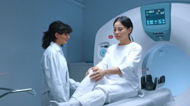 Tıbbi teknik asistan radyolojide manyetik rezonans tomografisiyle bilgisayarlı tomografi taraması hazırlıyor. Modern klinikte biyopsi yapılan bir hasta. İlaç, sağlık hizmetleri