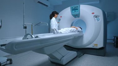Beyaz elbiseli hasta manyetik rezonans görüntüleme taramasından geçiyor, tomografi ya da PET taraması için yatağa uzanıyor, onkoloji makinesi vücudunu tarıyor. Manyetik rezonans tanısı x-ray.