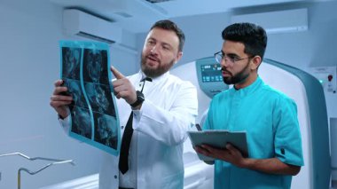 Nörobilim laboratuvarı toplantısı: Tıp öğrencisi bilim adamı ve nörolog cerrahın MRI taramalı tomografi tartışması. Beyin hasarı tedavisi için uzmanlar çalışıyor..