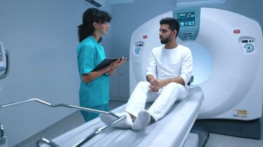 Pozitron emisyon tomografisi. Modern klinikteki hasta. Doktorlar biyopsi ve sağlık hizmetlerinin röntgen incelemesi hakkında açıklama yapıyor. Tıbbi tesisler modern teknoloji..