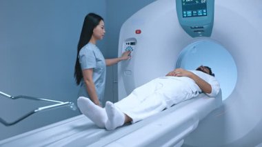 Doktor nörolog teşhis kliniğinde hasta için CT taraması yapıyor. Tıp hemşiresi MRI cihazına düğme takıyor. Manyetik rezonans görüntüleme insan vücudu üzerinde çalışıyor. İlaç, sağlık hizmetleri.