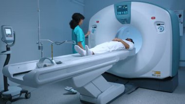 Profesyonel doktor ileri tıbbi teknolojiler kullanarak acil durum muayene prosedürü uygular. Hastanedeki teşhis odası, radyoloji uzmanı hastanın MRI, CT veya PET taramasını izliyor