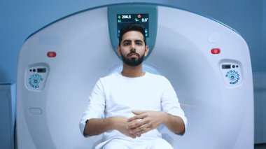 Manyetik rezonans tomografisi çekilen Hintli hasta. Yalan söyleyen hastayla MRI kapsülünün görüntüsü. Hasta tomografi incelemesi için hazırlanıyor. Ayarlama düğmesi olan MRI ekipmanları.